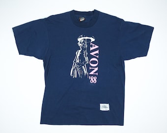 May include: A navy blue t-shirt featuring a white graphic of a person holding an umbrella. The text "AVON '88" is printed in pink on the shirt.