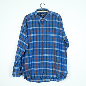 May include: A blue, green, and red plaid long-sleeve button-down shirt.
