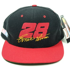 Peut inclure: Casquette de baseball noire et rouge avec le num&eacute;ro "28" et le nom "Ernie Irvan" brod&eacute;s en or sur le devant. La casquette a une visi&egrave;re rouge et une sous-visi&egrave;re verte.