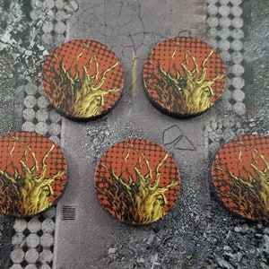 May include: Five round wooden tokens with a red and yellow design. The design features a stylized tree with branches and a textured background.