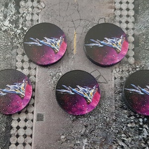 May include: Five round, black tokens with a pink and purple nebula background. A silver spaceship flies through the nebula.