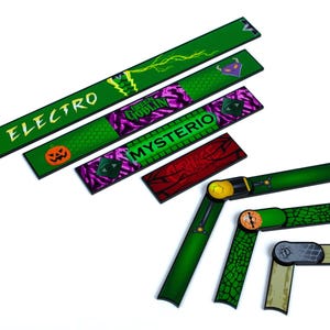 Może przedstawiać: Zielone i fioletowe maty barowe z nazwami postaci "Electro", "Green Goblin" i "Mysterio". Maty mają grafikę, w tym dynię, błyskawice i pajęczynę. Niekt&oacute;re maty są zawiasowe.