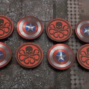 May include: Eight round red and silver tokens with a black skull and tentacles design on half and a blue star on a red and white circle on the other half.