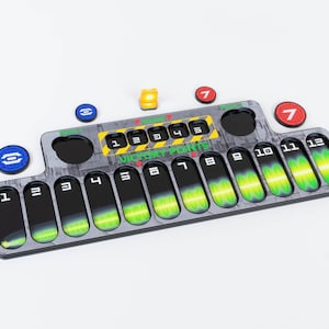 May include: A black and gray game board with a green and yellow progress bar. The board has numbers 1 through 12 and the words "Victory Points". There are also four small colored tokens on the board.