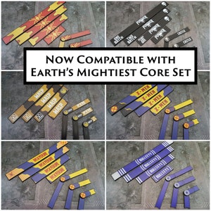 May include: A set of colourful, printed, rectangular game pieces with text and symbols. The pieces are compatible with Earth's Mightiest Core Set. The pieces include characters like Wolverine, Wasp, X-Men, and Bullseye.