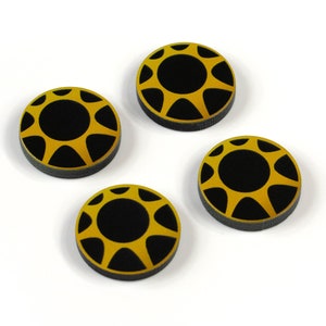 Peut inclure: Quatre jetons ronds noirs et dorés avec un motif de soleil. Les jetons mesurent environ 2,5 cm de diamètre.