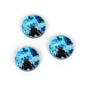 May include: Three round blue and white tokens with a black figure in the center. The figure is standing in front of a blue and white background.