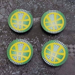 Puede incluir: Cuatro posavasos redondos, verdes y amarillos, con un diseño geométrico estilizado.