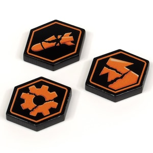 Puede incluir: Tres fichas de juego hexagonales con fondos negros y símbolos naranjas. Los símbolos son una bomba rota, un engranaje roto y una montaña rota.