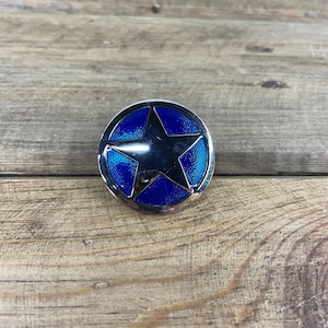 May include: A silver-toned metal belt buckle with a blue enamel star in the center.