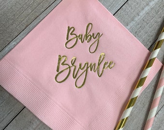 Może przedstawiać: Różowy papierowy serwetka z napisem "Baby Brynnlee" w złotej folii.