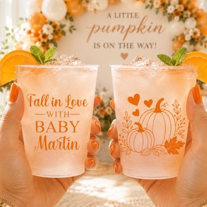 May include: Two clear plastic cups filled with an orange-tinted beverage, ice, and orange slices. One cup features the orange text 'Fall in Love WITH BABY Martin', while the other displays an orange graphic of pumpkins, leaves, and hearts.
