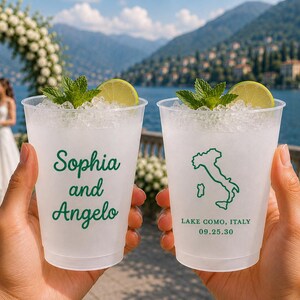 May include: Two clear plastic cups filled with ice, a lime wedge, and mint leaves. One cup features the green text "Sophia and Angelo," while the other displays a green outline of Italy with the text "LAKE COMO, ITALY" and "09.25.30" printed below.