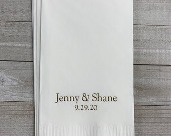 May include: White paper napkins with the text "Jenny & Shane 9.29.20" printed in brown ink.