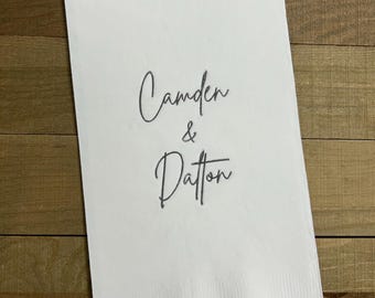 May include: White paper napkin with the text "Camden & Dalton" written in black cursive script.