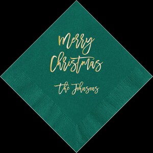 May include: Teal green paper napkin with gold foil lettering that says "Merry Christmas" and "The Johnsons".