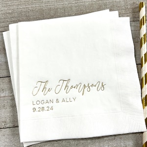 May include: White paper napkins with gold foil lettering. The text reads "The Thompsons, Logan & Ally, 9.28.24".