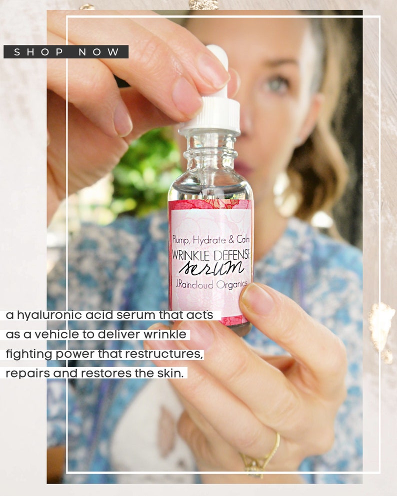 Puede incluir: Una botella de vidrio transparente con un gotero lleno de un suero de &aacute;cido hialur&oacute;nico. La etiqueta dice "Plump, Hydrate & Calm Wrinkle Defense Serum Raincloud Organics".