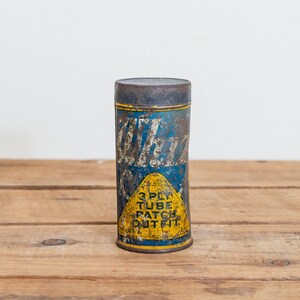 May include: Vintage tin can with blue and yellow label. The label reads "White  3 Ply Tube Patch Outfit".