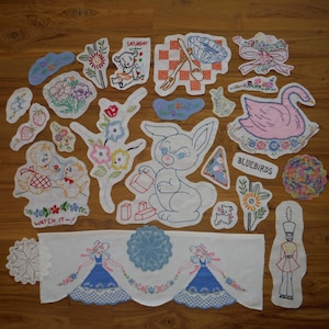 Puede incluir: Una colección de parches y apliques bordados con diversos diseños. Incluye un cisne, un conejo, motivos florales, osos de peluche y una pancarta con texto. La paleta de colores incluye rosa, azul y blanco, con texto como "WATCH IT!" y "BLUEBIRDS".