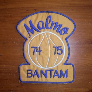 May include: A yellow and blue embroidered patch with a basketball and the text "Malmo Bantam 74 75".