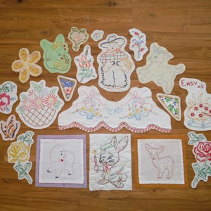 Puede incluir: Una colección de parches y apliques bordados vintage, con diseños florales, un vaquero, un conejito con una vela y un cordero. La paleta de colores incluye blanco, rosa, verde y amarillo, con algunas piezas delineadas con hilo rojo.