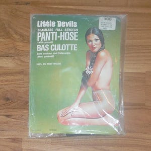 May include: Vintage "Little Devils" pantyhose package. The packaging, in a green hue, displays the text "PANTI-HOSE" and "BAS CULOTTE". The image shows a woman with dark hair. The product is described as seamless and full stretch.