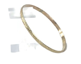 Puede incluir: Un brazalete de oro con un diseño floral intrincado.