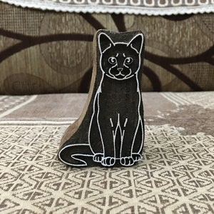Un chat assis, poterie, moule en céramique, scrapbooking, tjap batik, impression de tampons floraux sculptés.