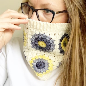 以下が含まれることがあります： 黄色と灰色の花柄の白いクロシェのネックウォーマー