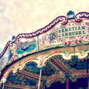 May include: A vintage-style carousel with a colorful, ornate design. The carousel is painted with floral motifs and the words "Venetian Carousel" in a decorative font.