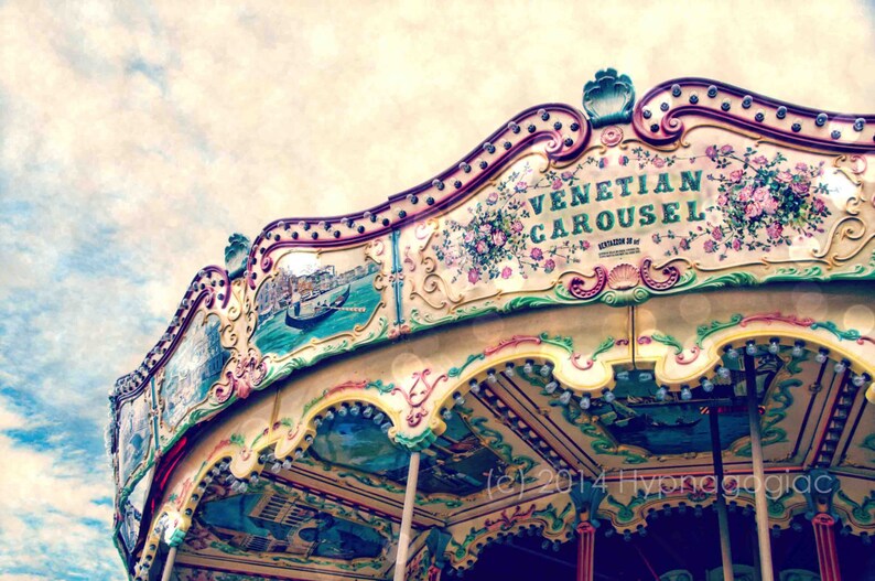 May include: A vintage-style carousel with a colorful, ornate design. The carousel is painted with floral motifs and the words "Venetian Carousel" in a decorative font.