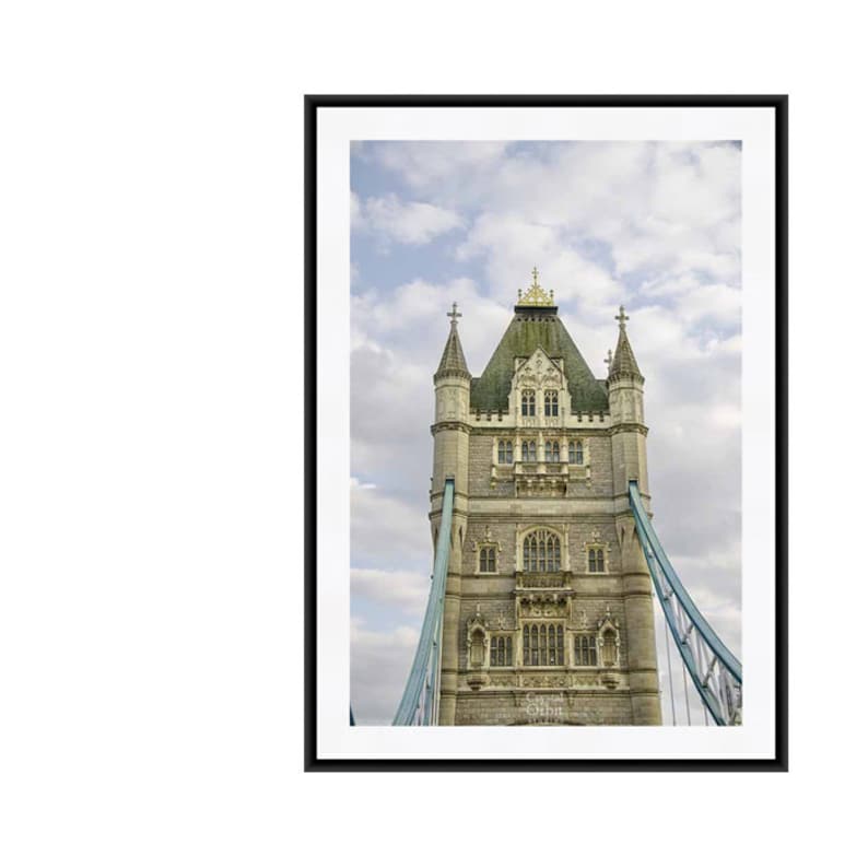 May include: A close-up view of the top of Tower Bridge in London, England. The bridge is made of stone and has two towers with pointed roofs. The towers are connected by a walkway. The sky is cloudy.
