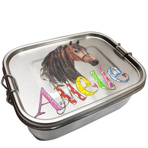 Peut inclure: Une boîte à lunch en acier inoxydable avec une illustration colorée de cheval et le nom "Amelle" écrit dans une police de caractères fantaisiste.