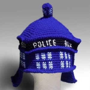 May include: Blue crocheted hat shaped like a police box with the text "POLICE BOX" on the front.