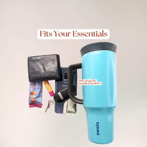 Carhartt water bottle bag capacity example showing essentials including a handled 40oz Owala water bottle, phone, wallet, keys, lip balm, snack bar, and cash. The Side Snap bag fits handled tumblers.