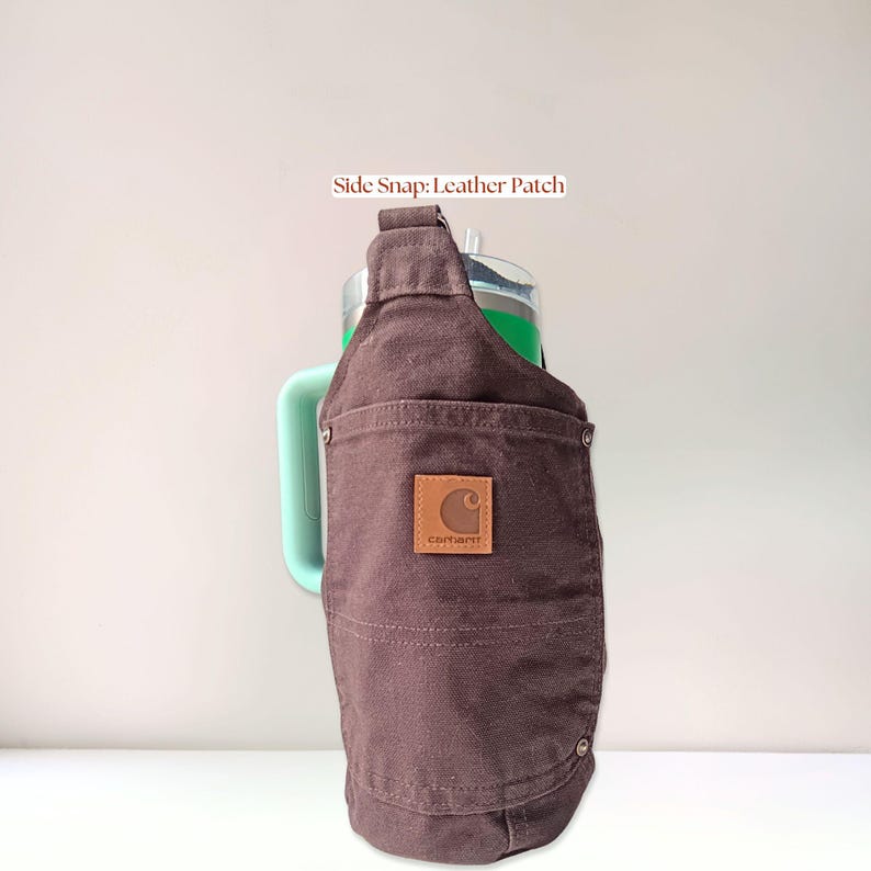 Back view of a chocolate brown canvas bottle holder featuring original leather Carhartt patch pocket with phone storage visible.