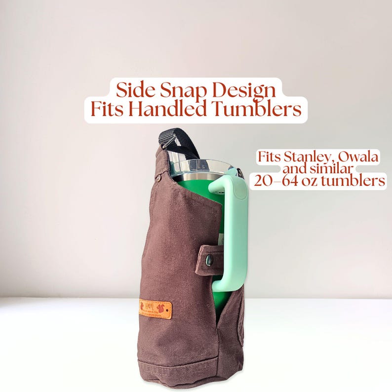 Water bottle holder with side snap strap securing a handled tumbler, demonstrating compatibility with large handled cups like Stanley tumblers.
