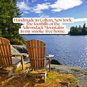 Two wooden Adirondack chairs overlooking a lake surrounded by autumn trees. All items are crafted in Colton, New York, in the foothills of the Adirondack Mountains in a smoke-free home.