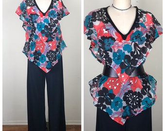 May include: A black and white floral print top with a ruffled neckline and short sleeves. The top is made of sheer fabric and has a V-neckline. The top is paired with black wide-leg pants.