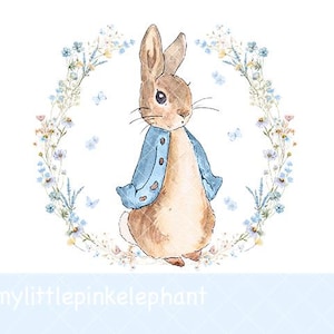 May include: Watercolor illustration of a brown rabbit wearing a blue jacket, standing inside a floral wreath with blue and yellow flowers and butterflies. The image has a soft, whimsical style, perfect for children's decor.