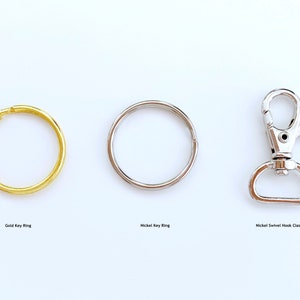May include: Three keychains: a gold key ring, a nickel key ring, and a nickel swivel hook clasp.