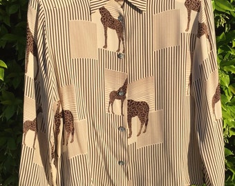 May include: A beige and brown striped button-up shirt with a giraffe print. The shirt has a collar and long sleeves. The label reads "Paolo Santoni".