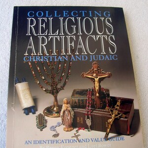May include: A book cover with the title "Collecting Religious Artifacts: Christian and Judaic" with an image of a menorah, a crucifix, a rosary, a scroll, and a statue of the Virgin Mary.