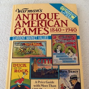 May include: A book cover with the title "Warman's Antique American Games 1840-1940: Current Market Values". The cover features illustrations of vintage board games, including "Boys Own Football Game", "Comical Conversation Cards", "Duck on the Rock", "Citie", and "Dick Tracy Super Detective Story Card Game".