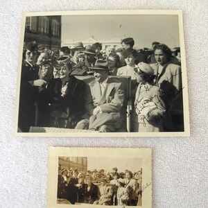 May include: Two vintage black and white photographs. The larger photo shows a group of people, including a man in a suit and hat, with signatures. The smaller photo also shows a group of people with signatures. Both photos are slightly yellowed with age.