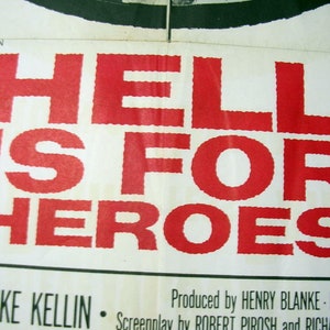May include: A vintage movie poster with the title "HELL IS FOR HEROES" in large, bold red letters. The text is printed on a cream-colored background. Additional text at the bottom includes names of cast and crew.
