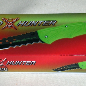 May include: A green and black folding knife with a skull and crossbones logo and the text "Tanto Hunter TX-080G" on the box.