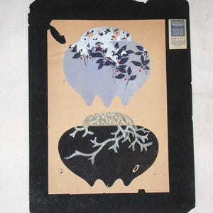 Puede incluir: Dos jarrones de cerámica en blanco y negro con diseños florales plateados. El jarrón superior tiene un fondo azul con flores blancas y bayas rojas. El jarrón inferior tiene un fondo negro con ramas plateadas. La imagen está enmarcada con un borde negro.