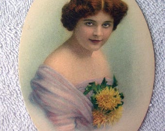 May include: Oval-shaped vintage portrait of a woman named Alice. She has auburn hair and is wearing a light purple shawl, holding yellow flowers. The text "ALICE @ THE G.B. CO. JOLIET, ILL" is printed at the bottom.